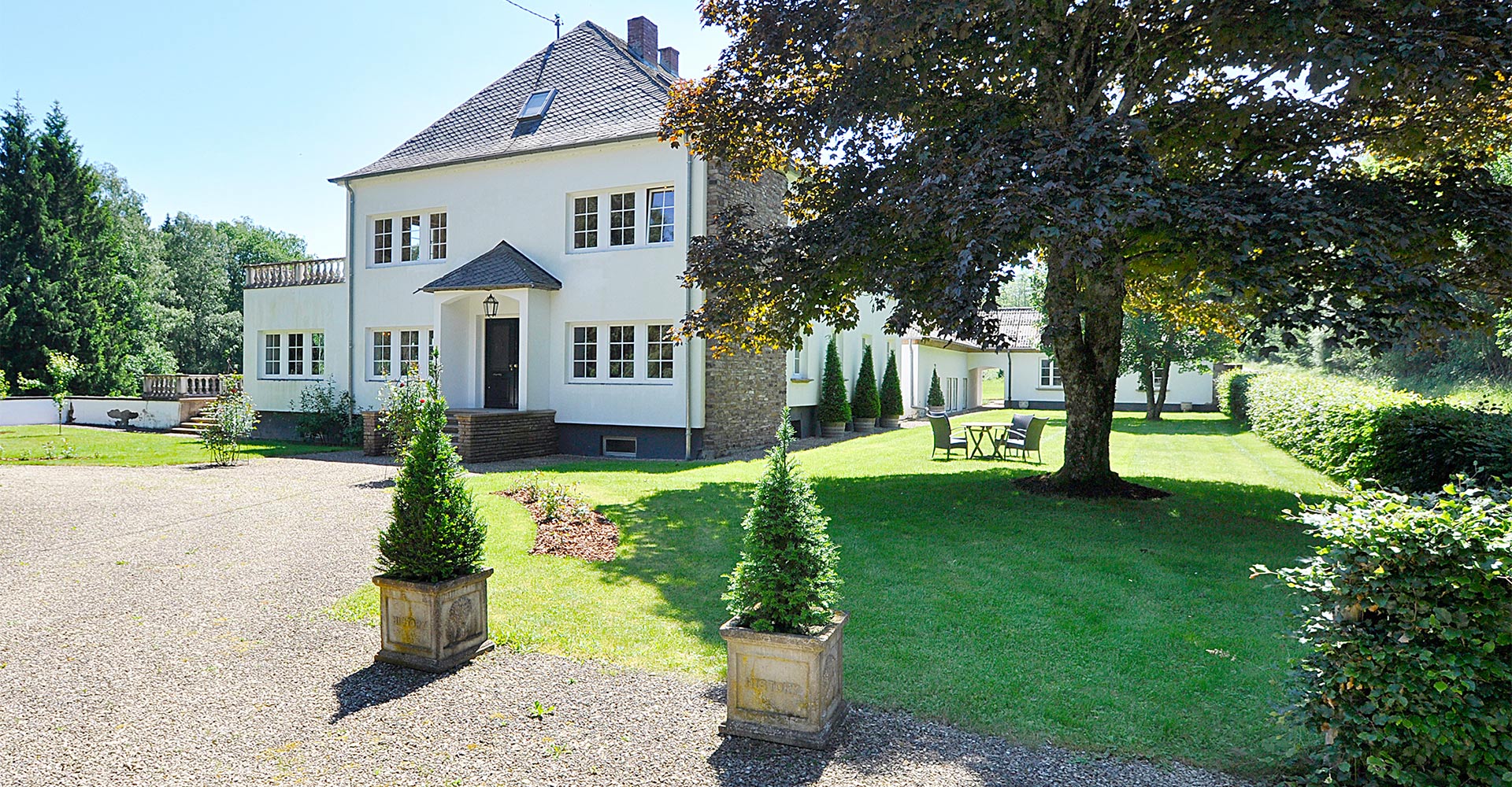 Weißes Einfamilienhaus mit Garten
